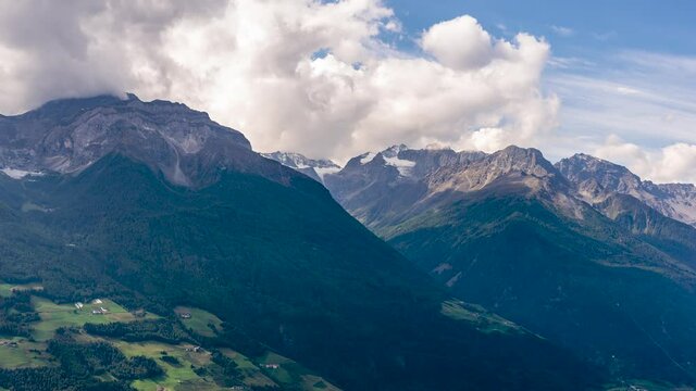 The mountains of the Ortler group on a sunny day with passing low clouds seen from Silandro, South Tyrol, Italy. Time lapse motion.