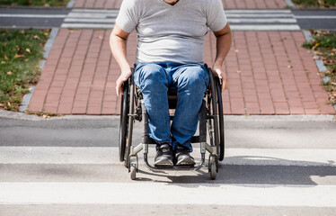 Handicapped man in wheelchair crossing street road