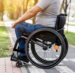 Handicapped man in wheelchair preparing to cross the road on pedestrian crossing