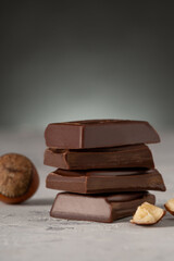 chocolate slices and hazelnuts on a dark gray background