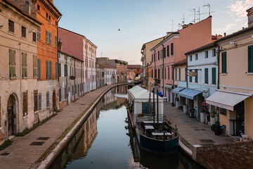 Fototapeta na wymiar Comacchio, Ferrara / Italy - August 2020: View of the historic center of Comacchio with its main canal, sky with clouds
