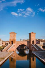 Comacchio, Ferrara / Italy - August 2020: Trepponti Bridge in Comacchio, blue sky with clouds