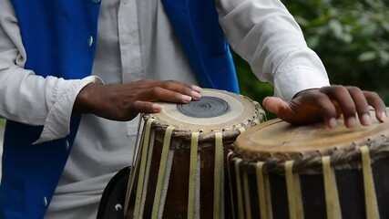 two men playing rabab and tabla traditional music instruments on road side for entertainment