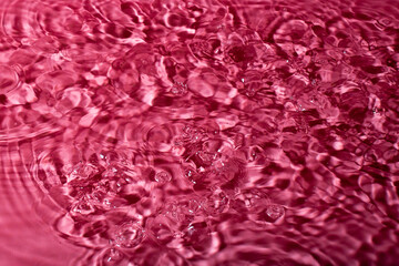 Fototapeta premium splash of water on a red background. Abstract wallpaper