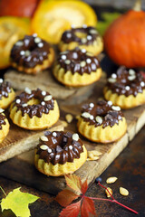 Pumpkin muffins with chocolate. Autumn desserts. Autumn composition with poke and cupcakes. Autumn mood.