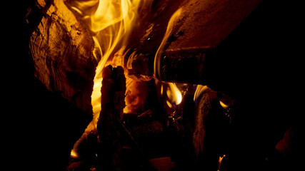 Close up shot of burning firewood in the fireplace. low light