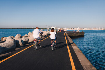 Obraz premium Marina di Ravenna, Ravenna / Italy - August 2020: People riding bicycles on the Zaccagnini pier
