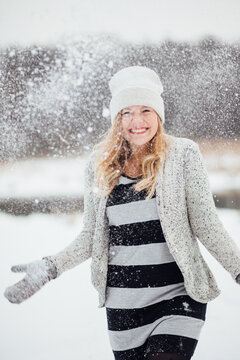 Young woman in winter holding snow in her hands