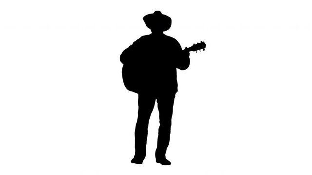 Silhouette Cowboy man with acoustic guitar singing a song.