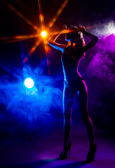 Beautiful slim sexy dancer girl wearing lingerie and high heels posing in the rays of light in a colorful smoke. Artistic, conceptual, silhouette,commercial and advertising design