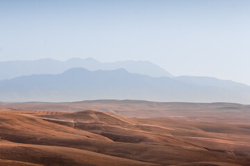Naklejka premium dry landscape of sand dunes and mountains in the background