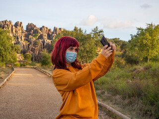 Mujer joven pelirroja haciendose un selfie en el cerro del hierro, sevilla, andalucia, españa con...