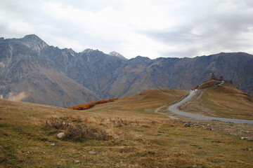 Fototapeta na wymiar Colorful autumn landscape with Gergeti Trinity Church on a background of Caucasus Mountains, Georgia.