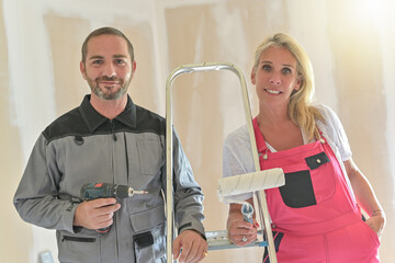 Portrait of a couple finishing paint jobs in their new apartment