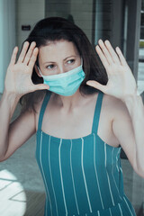 Coronavirus. Sick woman of corona virus looking through the window and wearing mask protection and recovery from the illness at hospital. Quarantine. Patient at hospital. Prevent infection.