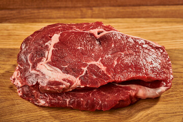 Piece of raw meat on wooden cutting board