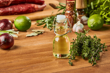 Small bottle of seed oil and bunch of thyme on wooden table