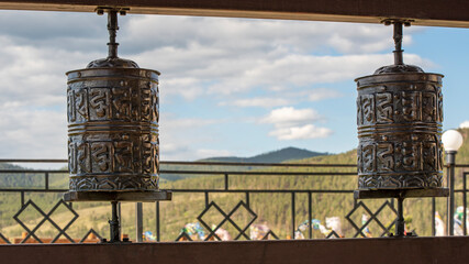 two Buddhist prayer drums with inscriptions on the sky background