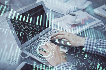 Technology theme hologram with man working on computer on background. High tech concept. Double exposure.