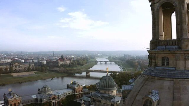 Drone footage of golden Fama figure statue on top of Zitronenpresse with Frauenkirche in background in Dresden, Germany