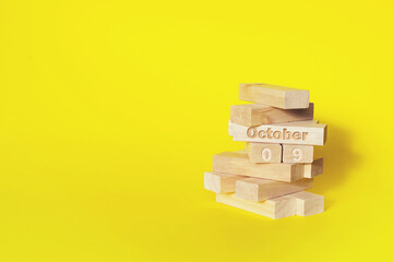 October 9th. Day 9 of month, Calendar date. Wooden blocks folded into the tower with month and day...