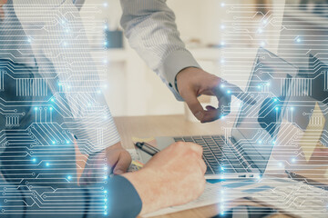 Technology theme hologram with man working on computer on background. High tech concept. Multi exposure.