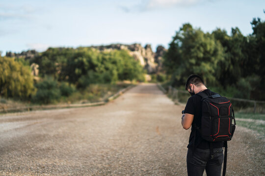 Chico parado mirando fotograf&iacute;a de la camara en la sierra de sevilla, cerro del hierro