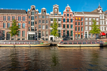 Medieval houses and cruise boats in the city center from Amsterdam in the Netherlands