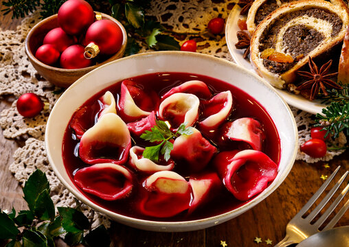 Traditional Christmas beetroot soup borsch with dumplings stuffed with mushrooms close up view