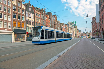 Fototapeta na wymiar Tram driving at Damrak in Amsterdam the Netherlands