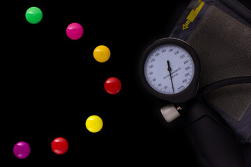 medical tonometer, background frame made of colored magnetic paper clips on black background with space for text