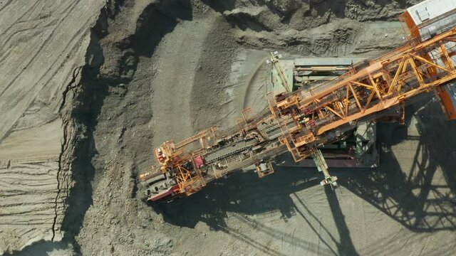 Aerial view of bucket wheel excavator in process of mining natural resource. Heavy industry.
