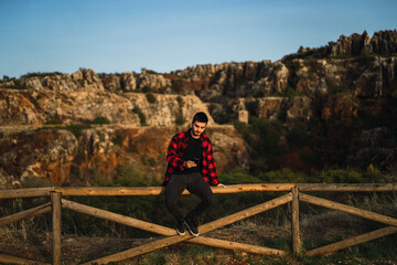 Fototapeta na wymiar Chico joven con camisa roja estilo leñador en parque natural cerro del hierro,sevilla