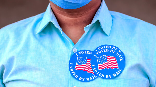 Voting Fraud Concept. Lack of trustworthiness for Mail-in voting. Man puts multiple I Voted By Mail stickers on the shirt.