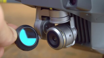 A close-up shot of a hand holding an nd or pl neutral density filter for unmanned cameras, drones, or copters.