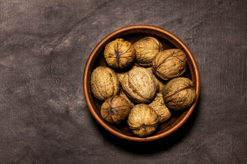 Walnuts in a clay bowl on a light background