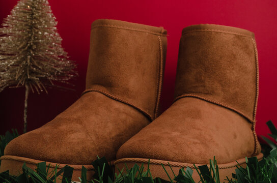 botas de invierno color marr&oacute;n con decoraci&oacute;n de navidad y fondo liso de colores
