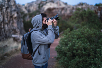 Chico joven con mascarilla negra tomando fotografías