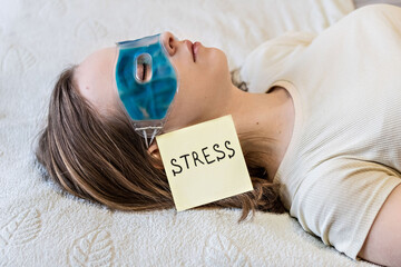 Young woman relaxing with a cooling gel eye mask on her face. The concept of psychological problems...