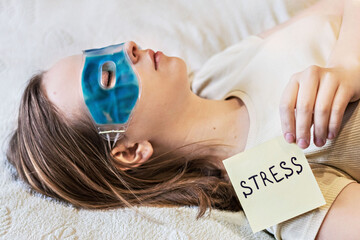 Young woman relaxing with a cooling gel eye mask on her face. The concept of psychological problems...