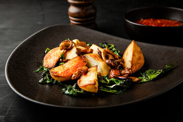 Roasted potatoes with mushrooms and basil on a plate
