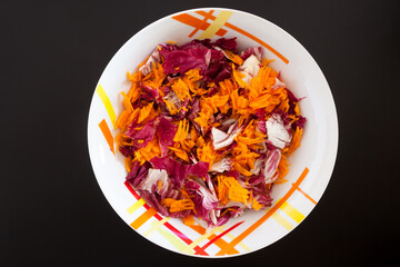 Salad with carrots on black table, top view