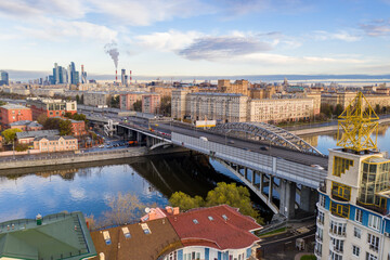 Obraz premium cityscape at sunrise on autumn morning with old houses, highways and river shot from drone