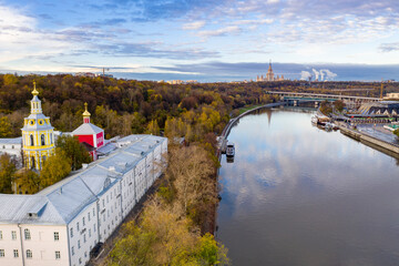 Naklejka premium cityscape at sunrise on autumn morning with old houses, highways and river shot from drone