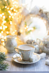 A cup of English tea with milk from an old mother-of-pearl porcelain service with refined sugar....