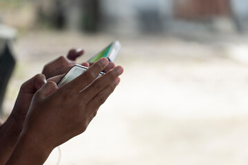 Child's hand holding a smartphone for playing or chart message.