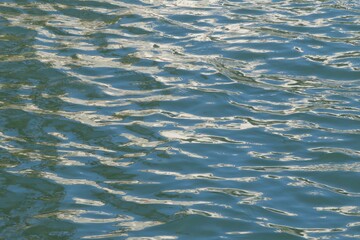 Turquoise ripples water surface with sun glare in Florida lake, natural background