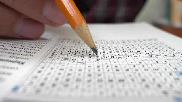 Young university student marking the important words from his lectures. Class notebook. Selective focus on example text book. Close up on student hands studying and doing homework.