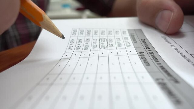 Young university student marking the important words from his lectures. Class notebook. Selective focus on example text book. Close up on student hands studying and doing homework.