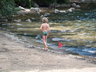 Enfant jouant avec une épuisette à la plage